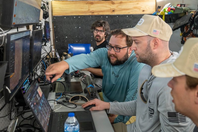 Perseus Defense personnel reviewing equipment and test data at Yuma Proving Ground.