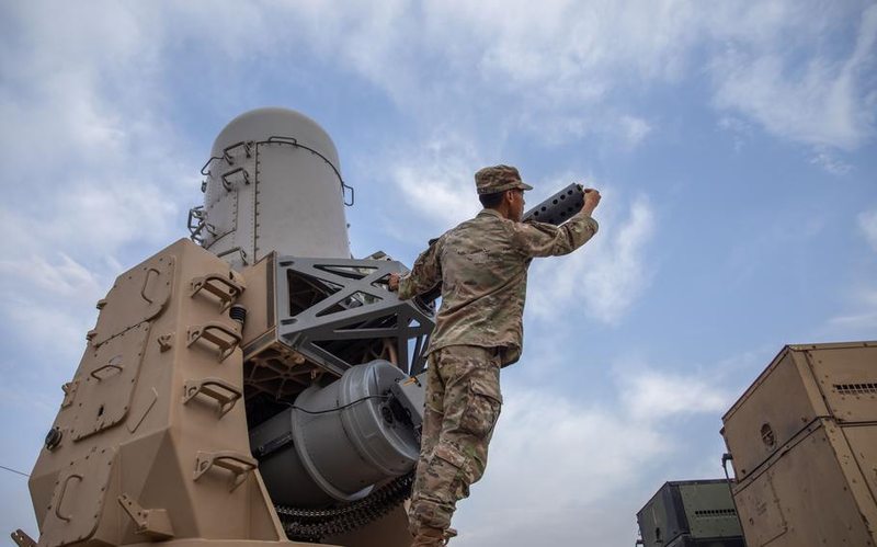 A soldier inspecting a counter-rocket, artillery and mortar gun.