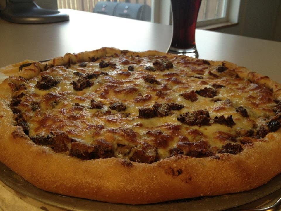 A thick-crusted sirloin chili pizza covered in melted cheese on a plate.