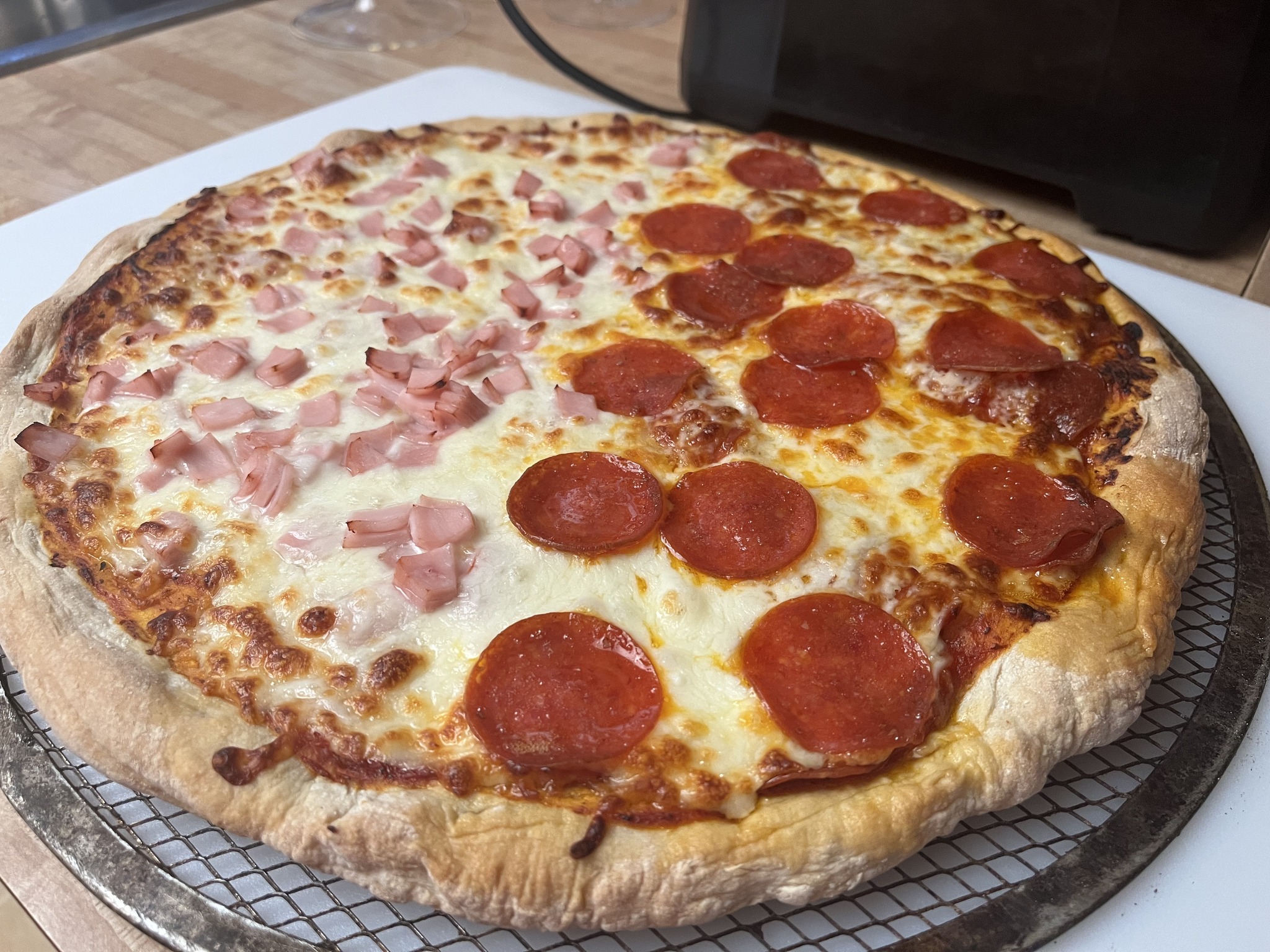 The Thursday pizza with pepperoni on one half and a pink diced topping on the other, before green garnish.
